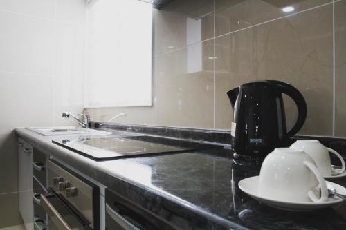 a kitchen counter with affeepot and a tea kettle at AH Hotel in Antofagasta