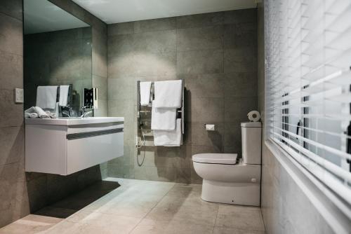 a bathroom with a toilet and a sink at The Grange Motel in Christchurch