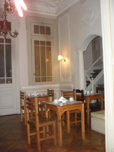 a dining room with tables and chairs and a mirror at Hotel De La Rue in Buenos Aires
