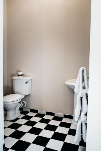 a bathroom with a toilet and a black and white checkered floor at The Grange B&B in Christchurch