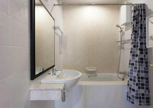y baño blanco con lavabo y ducha. en Sirinan Villa Nimman ChiangMai en Chiang Mai