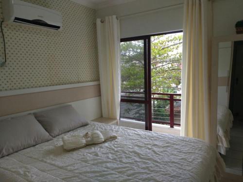1 dormitorio con 1 cama con 2 toallas en Apartamento 3 quartos, en Itapema