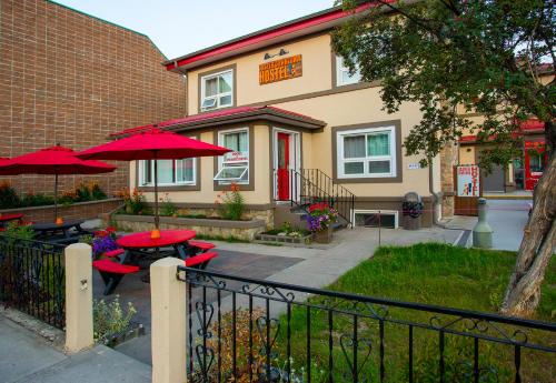a restaurant with tables and umbrellas in front of a building at Jasper Downtown Hostel in Jasper
