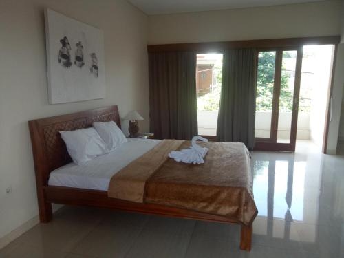 a bedroom with a bed with a towel on it at Karta House in Ubud