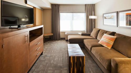 a living room with a couch and a flat screen tv at Best Western Plus CottonTree Inn in Idaho Falls