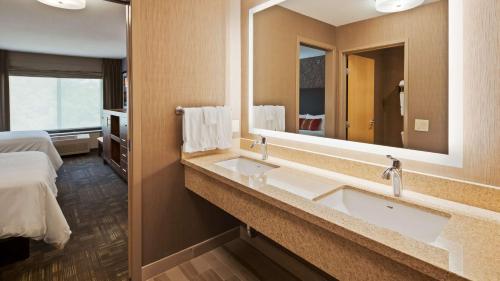 a bathroom with a sink and a large mirror at Best Western Plus CottonTree Inn in Idaho Falls