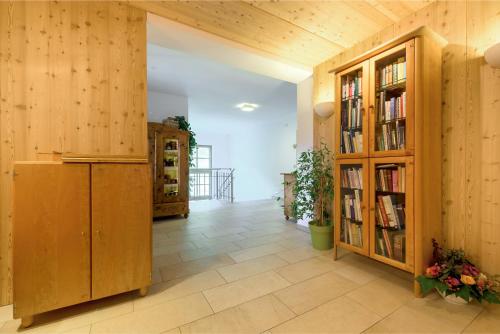 a large room with wooden bookshelves and a hallway at ARCHE Hof Öbristhof in Kleinarl