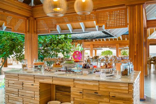 a restaurant with a counter with food on it at Kudafushi Resort & Spa in Raa Atoll