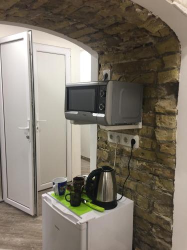 a kitchen with a microwave and a tv on a wall at Hostel Train Station in Kyiv