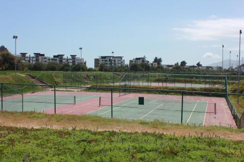 two tennis courts on a field with buildings in the background at Depto Maitencillo frente al Mar - Costamai in Maitencillo