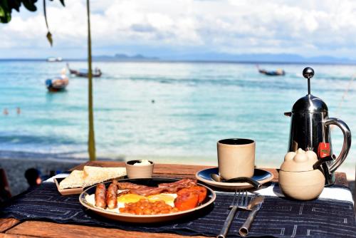 een bord ontbijt op een tafel met het strand bij Castaway Resort Koh Lipe in Ko Lipe