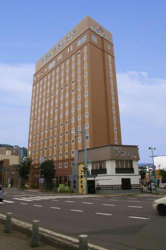 a large brown building with a street in front of it at Route Inn Grantia Hakodate Goryokaku in Hakodate