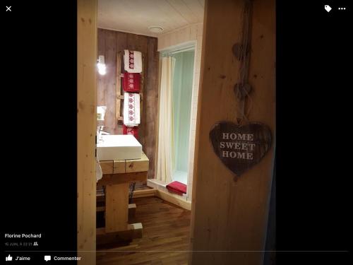 a bathroom with a sink and a sign that reads home sweet home at La Ferme de Là-haut B&B in Le Haut-du-Them