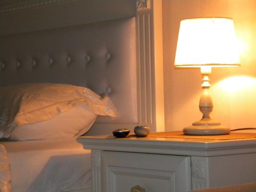 a lamp on a table next to a bed at DeLight Apartments in Boryspilʼ
