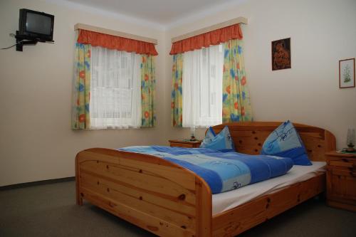 a bedroom with a wooden bed with blue sheets at Gästehaus Golker in Bad Gastein
