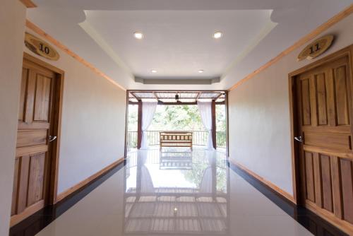 an empty hallway with two doors and a chair at Thongphaphum River in Thong Pha Phum