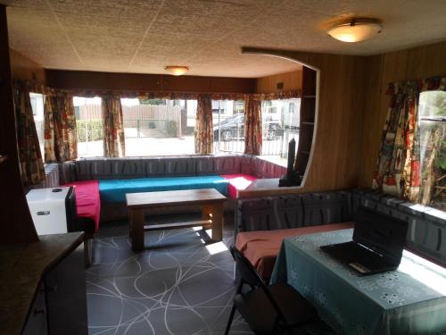 Zimmer mit Sofa, Tisch und Laptop in der Unterkunft Au Beau Rivage in Trois-Ponts