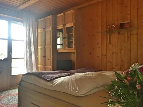 1 dormitorio con 1 cama en una habitación con paredes de madera en Apartment "Birgit" Sonnleitn/Nassfeld, en Sonnenalpe Nassfeld