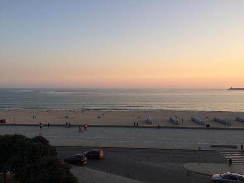 a view of a beach with people and the ocean at Oporto beach apartment in Matosinhos