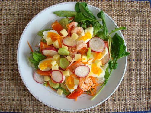 a white plate with a salad on a table at Viang Yonok Hotel, Restaurant, Sports Club in Chiang Saen