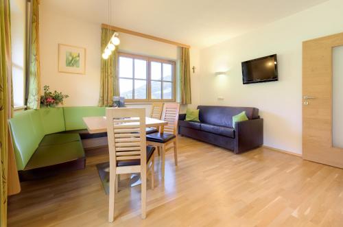 a living room with a table and a couch at ARCHE Hof Öbristhof in Kleinarl