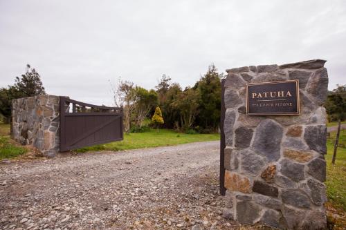 a sign for a park with a gate on a gravel road at Patuha Rainforest Retreat in Okato