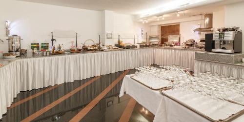 a restaurant with white tables and a kitchen at Hotel Drei Könige Luzern in Lucerne