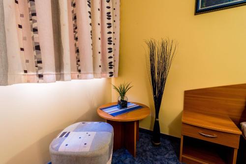 a small table and a stool in a room with a window at Hotel Rostov in Pleven
