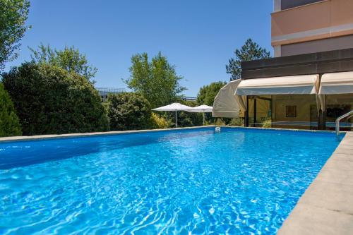 una grande piscina blu accanto a un edificio di Hotel Palace del Conero a Osimo