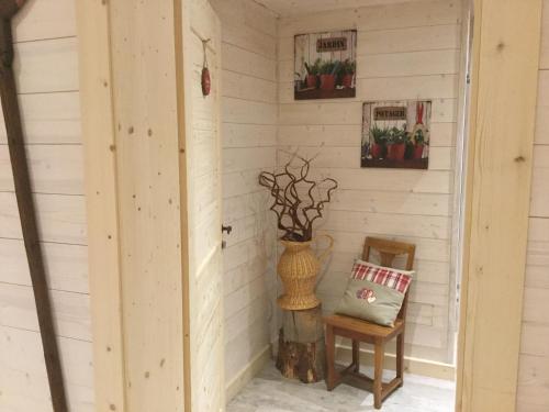 a corner of a room with a vase and a chair at La Ferme de Là-haut B&B in Le Haut-du-Them