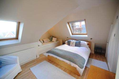 a small bedroom with a bed and two windows at The Lilac Door in London