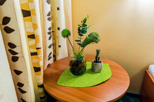a table with a vase with flowers on it at Hotel Rostov in Pleven