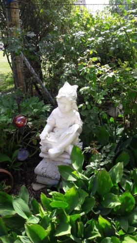 a statue of a child sitting on a rock in a garden at Ferienhaus Planetz in Kaindorf
