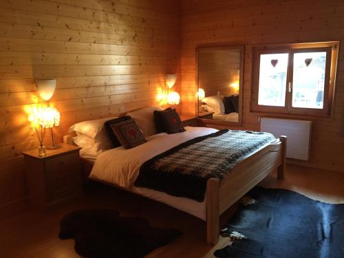 a bedroom with a bed with two lamps and a window at Celine 9, Champery in Champéry