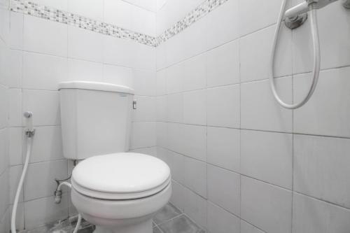 une salle de bain blanche avec toilettes et douche dans l'établissement RedDoorz near Hartono Mall, à Yogyakarta
