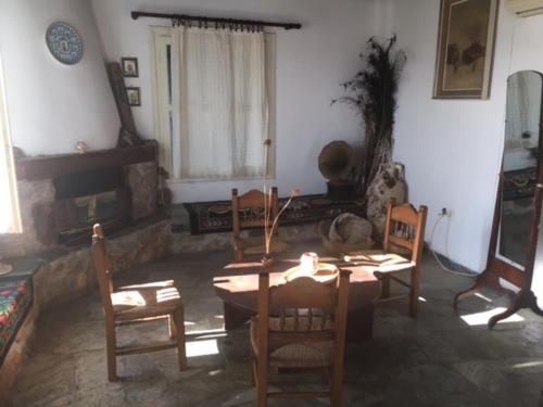 a living room with a wooden table and chairs at Aiolos in Skala