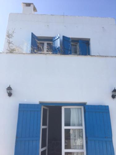 a blue and white building with a window at Aiolos in Skala
