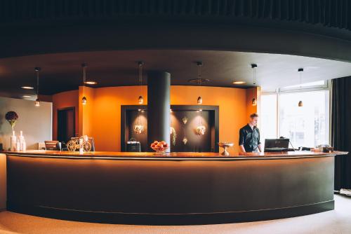 a man standing at a bar in a room at Vienna House Easy by Wyndham Trier in Trier