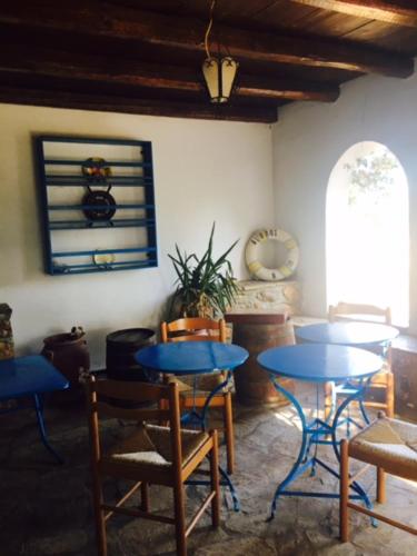 a room with blue tables and chairs and a window at Aiolos in Skala