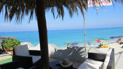 a view of the beach from a resort with chairs and umbrellas at Villaggio Camping Fiorina in Capo Vaticano