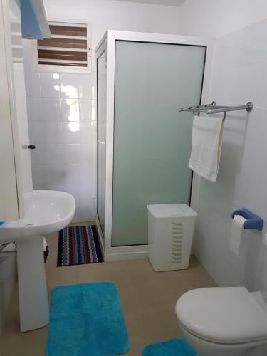 a bathroom with a toilet and a sink and a shower at VillaFleurie in Le Gosier