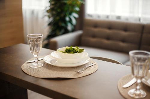 a table with a plate of food and two glasses at Old Town Trio Apartments in Vilnius