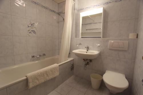 uma casa de banho com um lavatório, um WC e uma banheira em Rosat 3 em Château-d'Oex