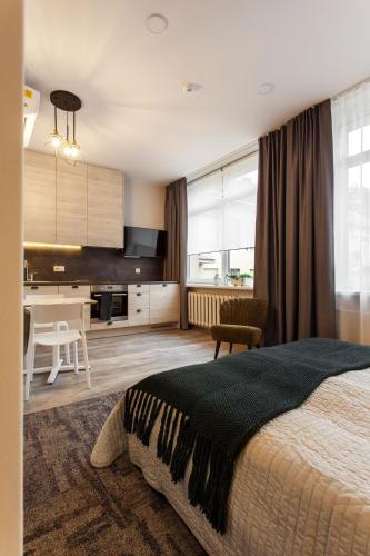 a bedroom with a large bed and a kitchen at Old Town Trio Apartments in Vilnius