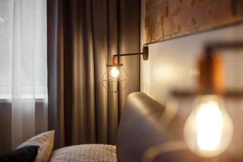 a lamp in a room next to a curtain at Old Town Trio Apartments in Vilnius