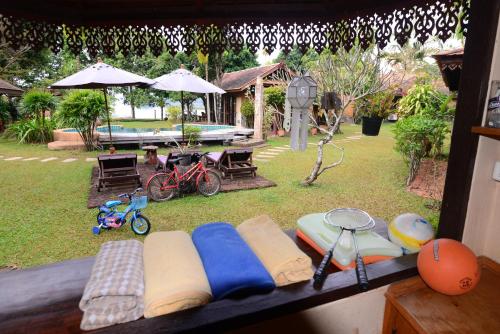 a view of a backyard with surfboards and a pool at Viang Yonok Hotel, Restaurant, Sports Club in Chiang Saen