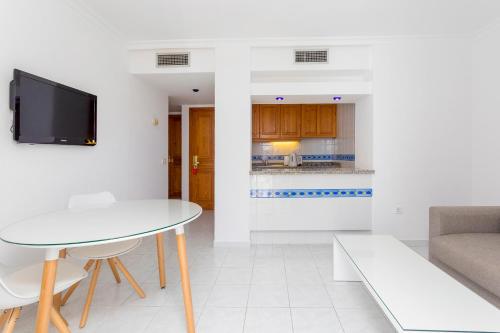 a living room with a table and a couch at Aparthotel Duquesa Playa in Santa Eularia des Riu