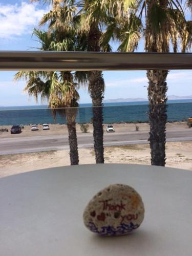 a window with a view of the beach and palm trees at Sea Breeze Hotel in Mastichari