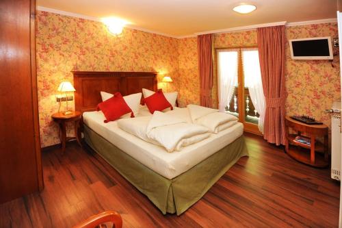 a bedroom with a large bed with red pillows at Landhaus am Waldrand in Ramsau