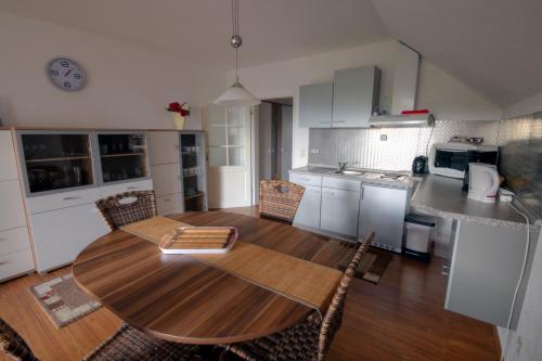 ヴィンターベルクにあるFerienwohnung Neagu mit 2 Apartementsのキッチン、ダイニングルーム(木製のテーブルと椅子付)